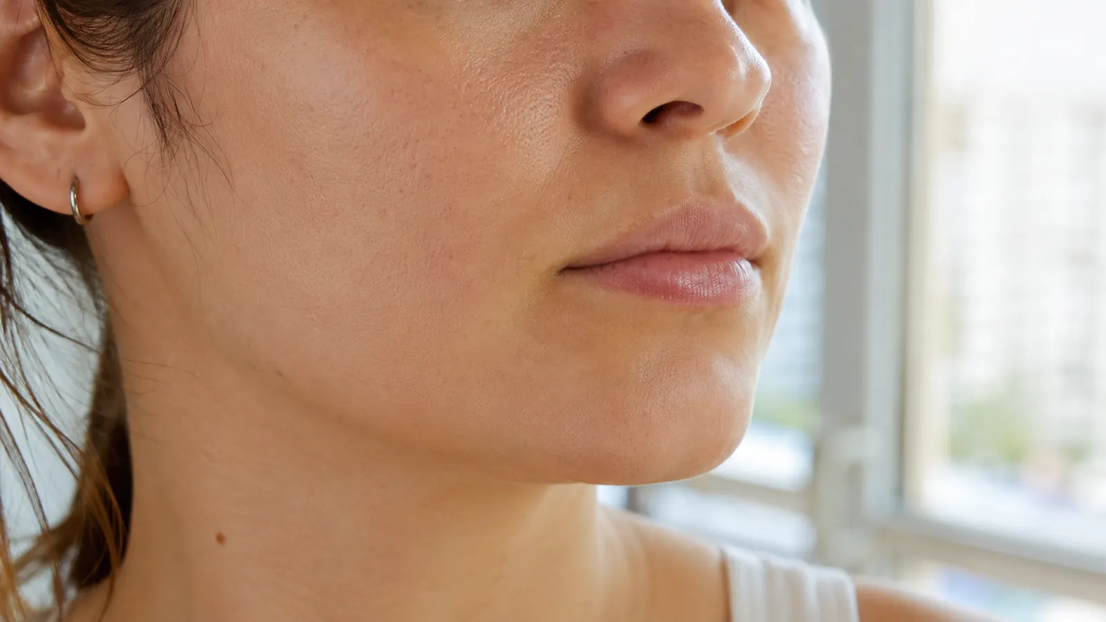 Close-up of a woman's glowing, even skin tone in natural daylight