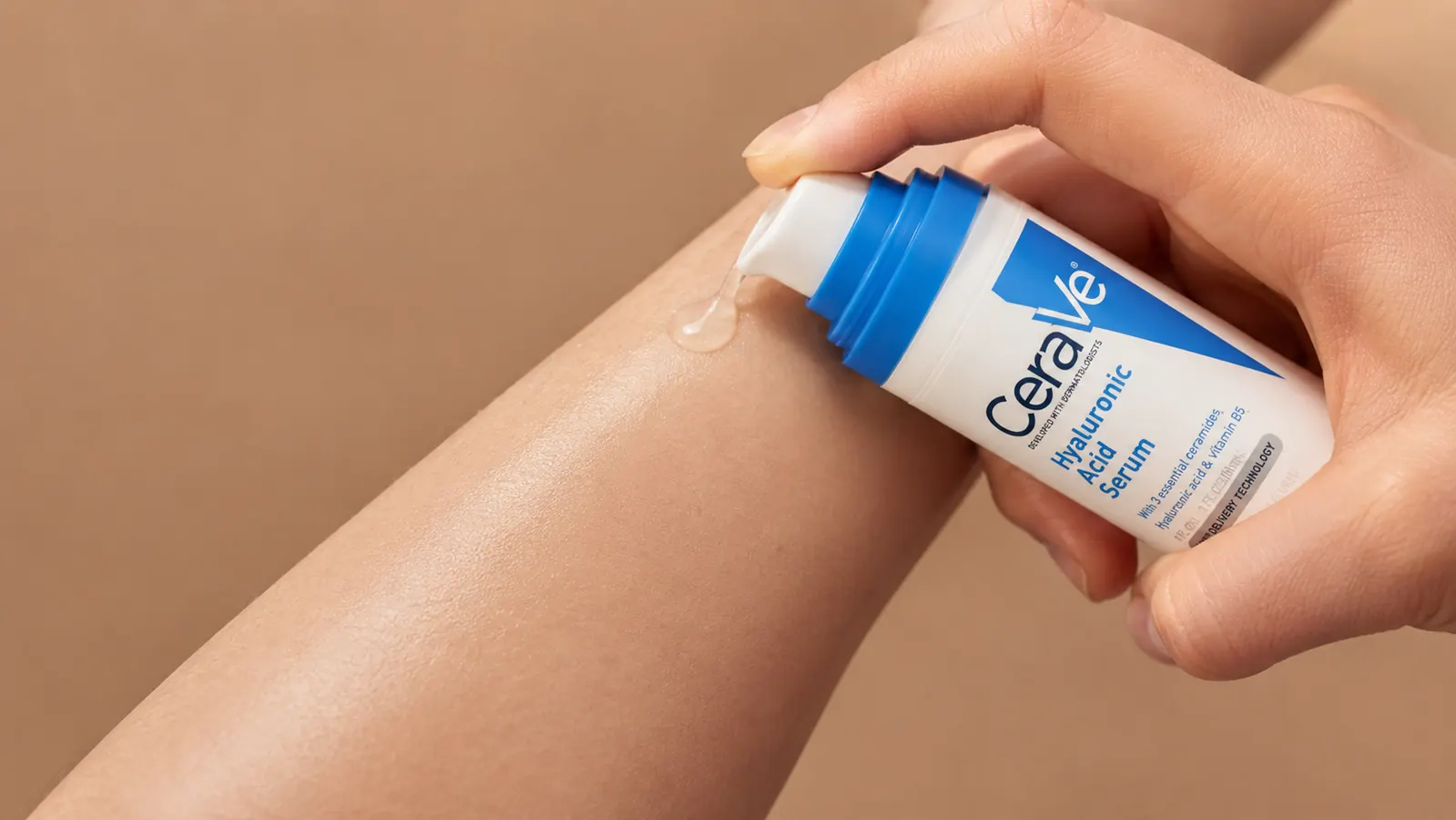 Close-up of serum being pressed into skin on a forearm, clear slightly viscous texture visible