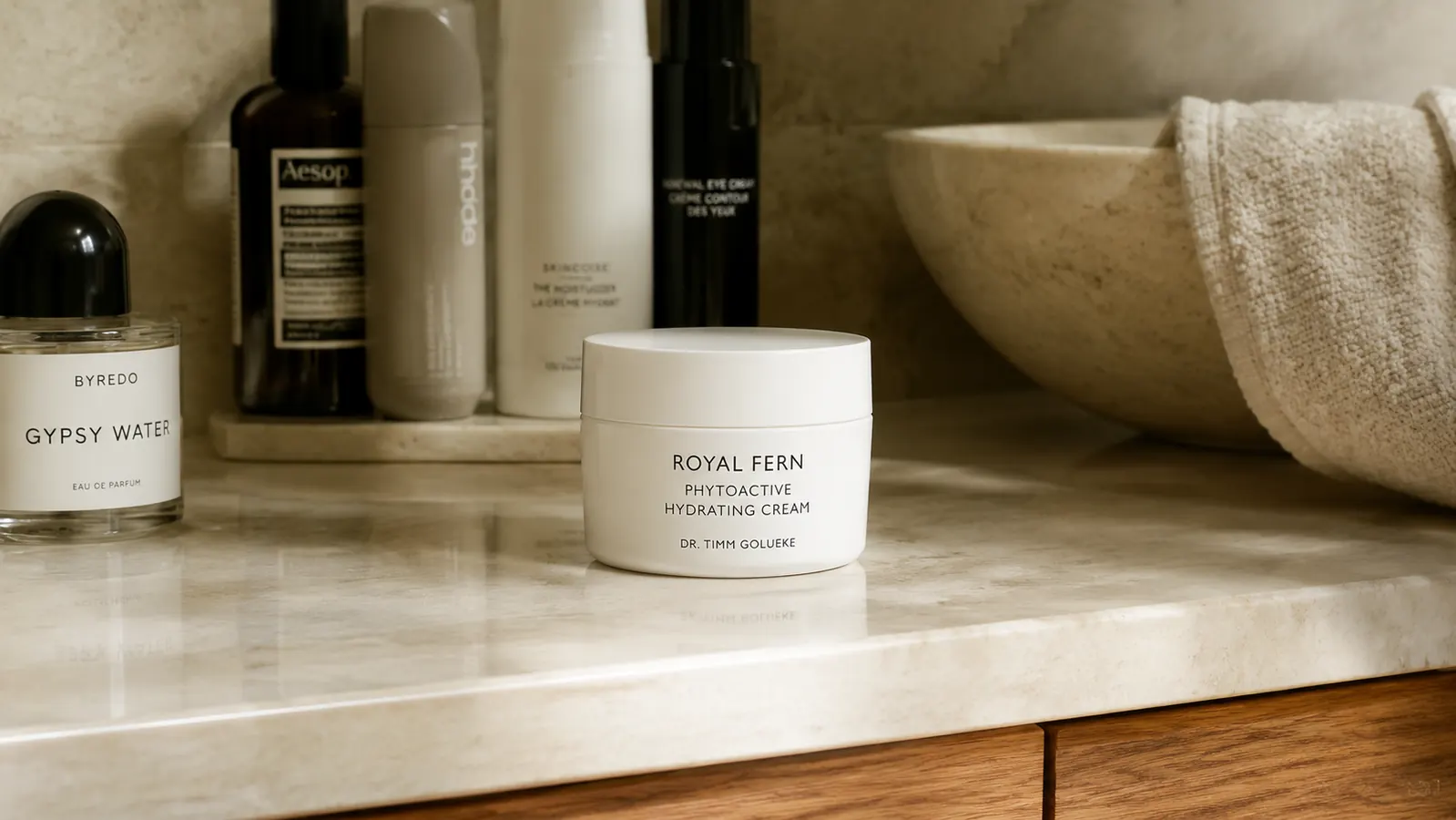 Bathroom shelf with a small lineup of skincare bottles and one white jar centered