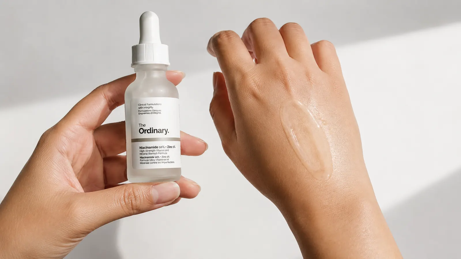 Close-up of clear gel serum texture on the back of a hand, showing lightweight consistency